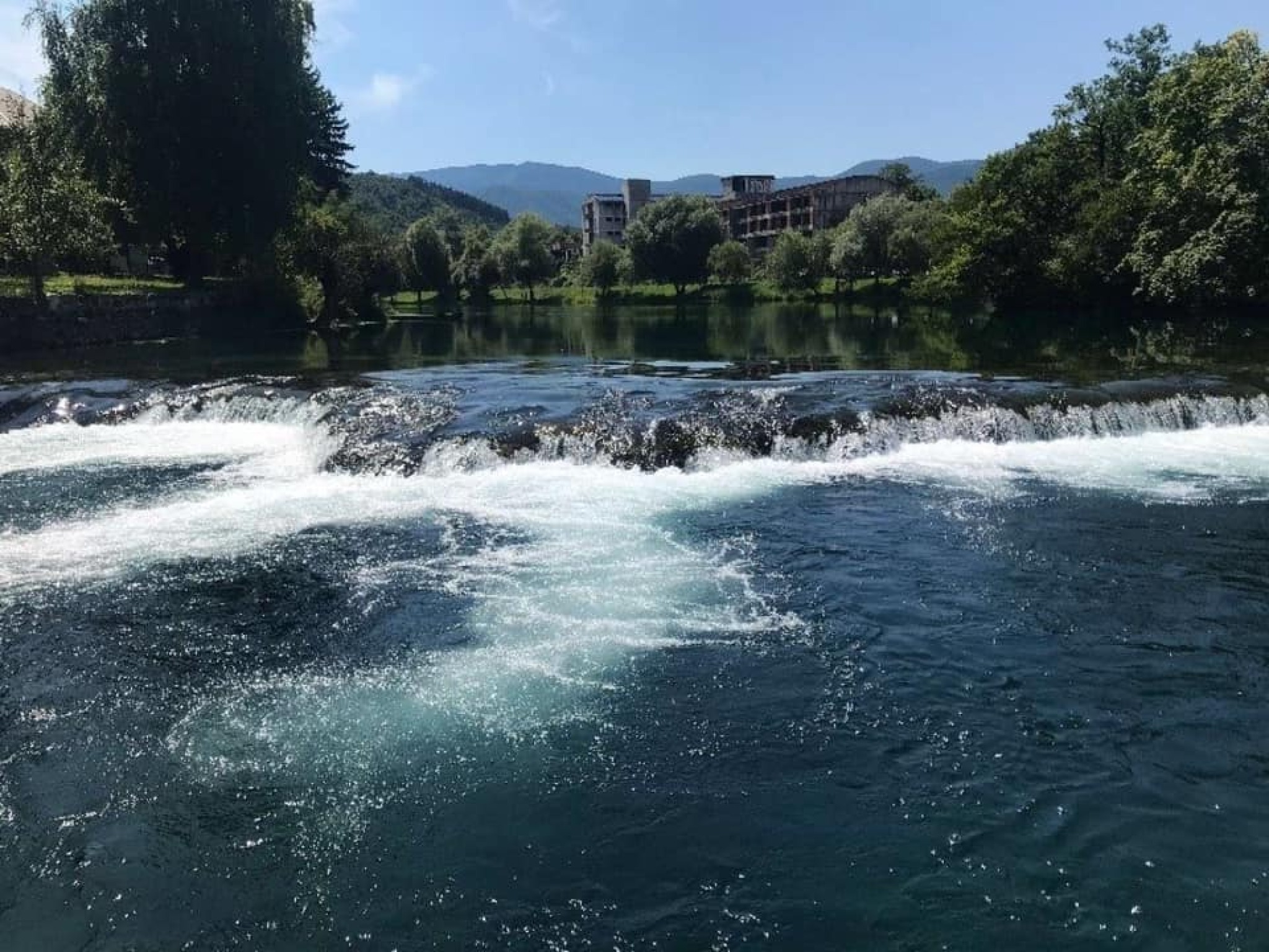 The Una River and Dom penzionera in the background. Photo by Azra Hromadžić, 2019.