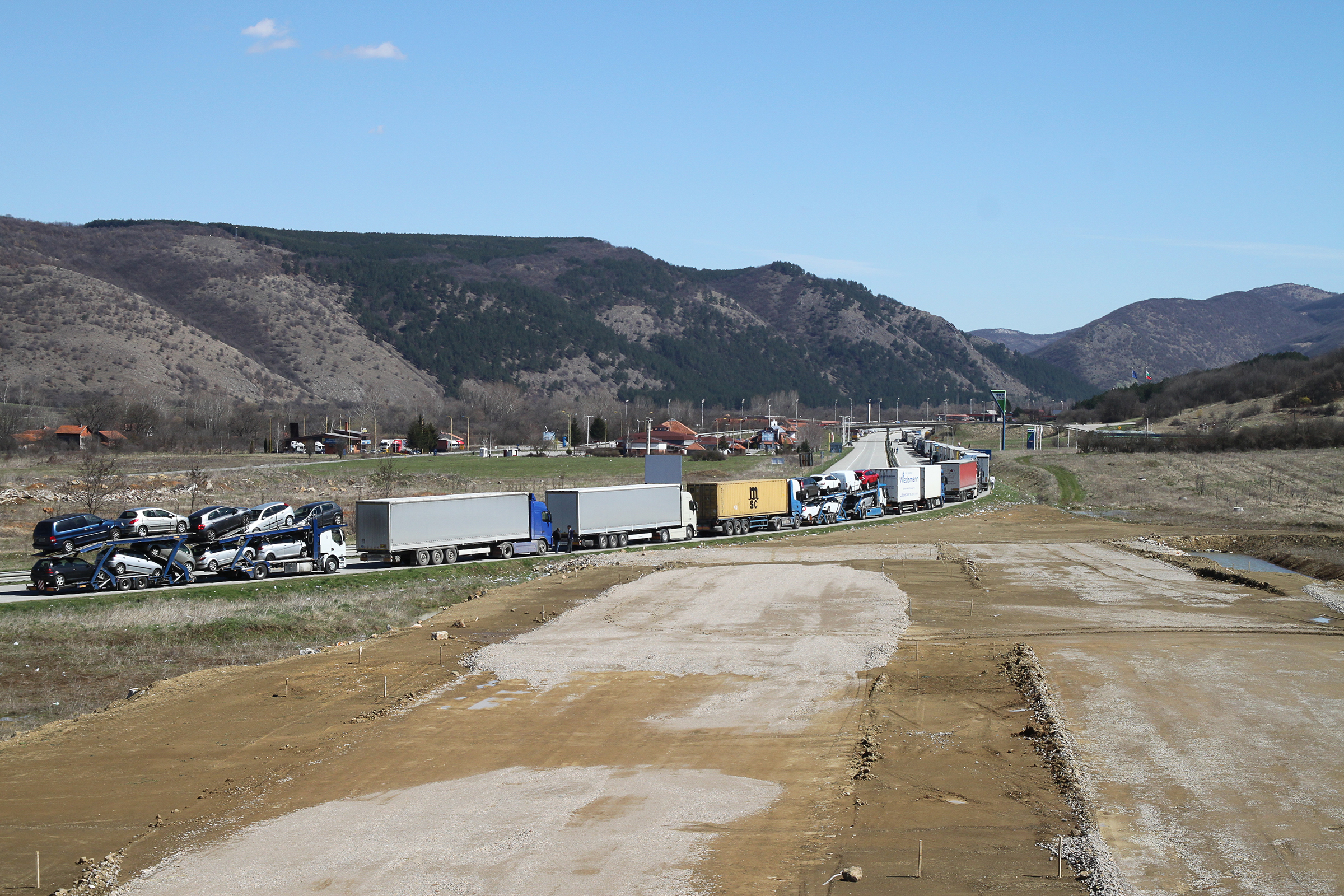 Corridor 10. E80 between Dimitrovgrad and Kalotina: trucks queuing up at the Serbian border to Bulgaria. In the foreground the levelled route for the new motorway section, financed and constructed with the participation of Chinese companies.